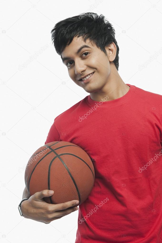 Man holding a basket ball and smiling