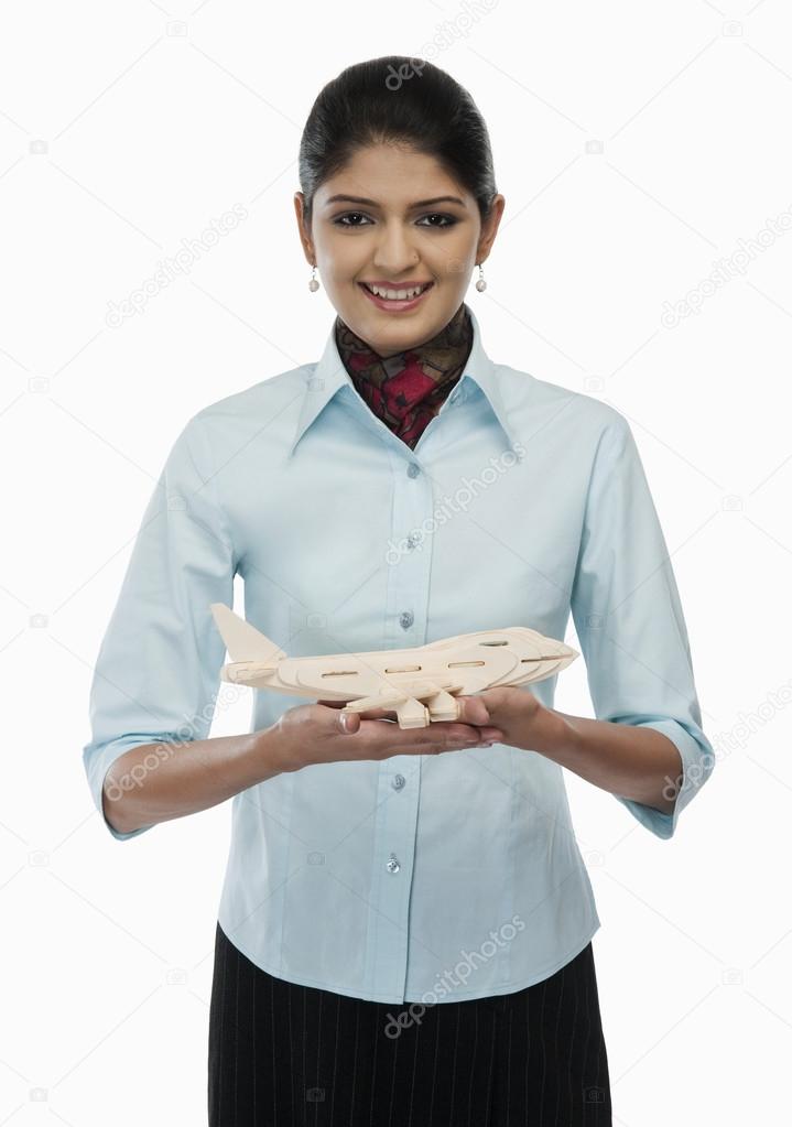 Female flight attendant holding a toy airplane