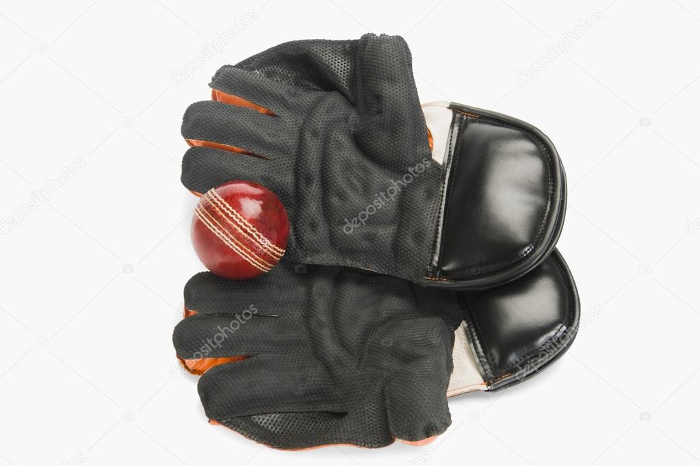 Cricket ball on wicket keeping gloves