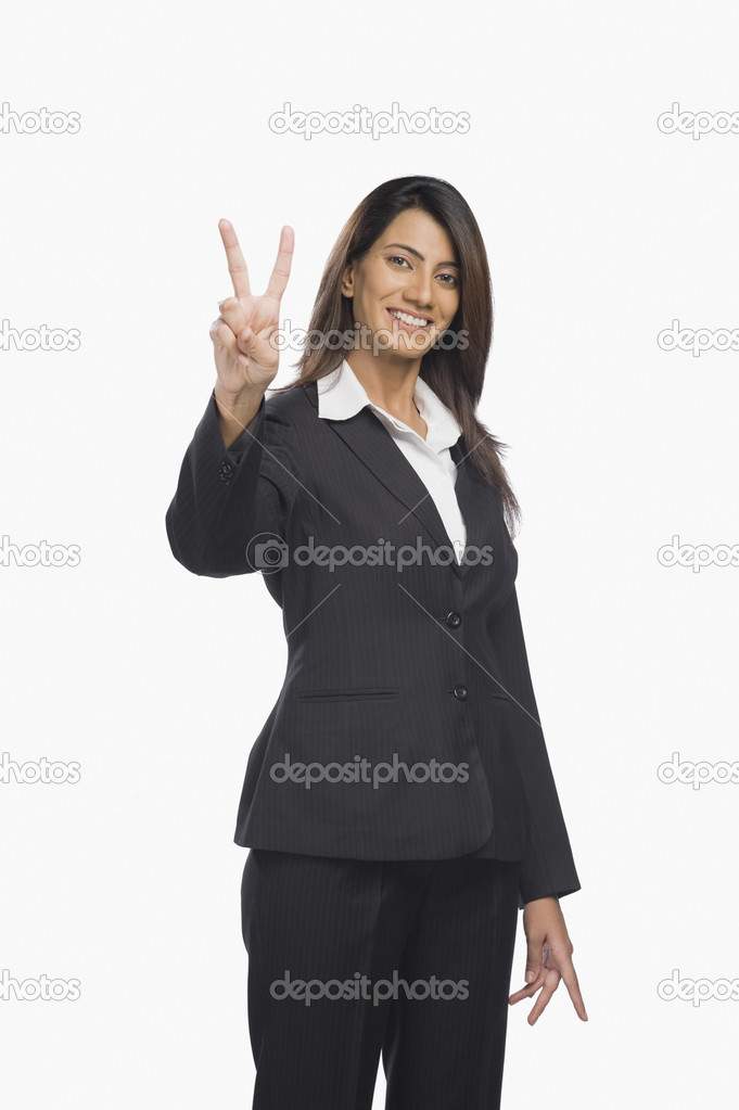 Businesswoman gesturing victory sign