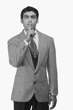 Parmakları dudaklarında bir iş adamı.