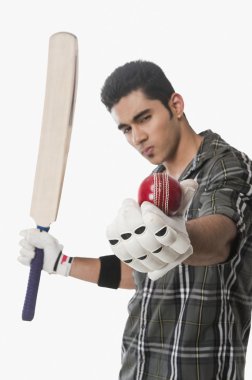 bir top ve sopayı tutan kriket oyuncusu