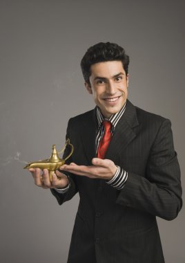 Businessman holding a magic lamp clipart