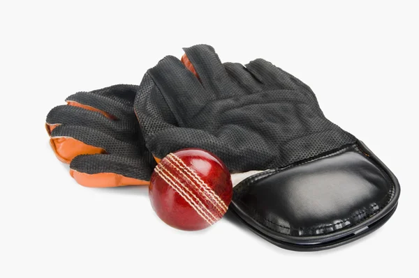 Cricket ball with a pair of wicket keeping gloves — Stock Photo, Image