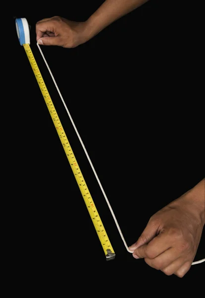 Uomo che misura la corda con un metro a nastro — Foto Stock
