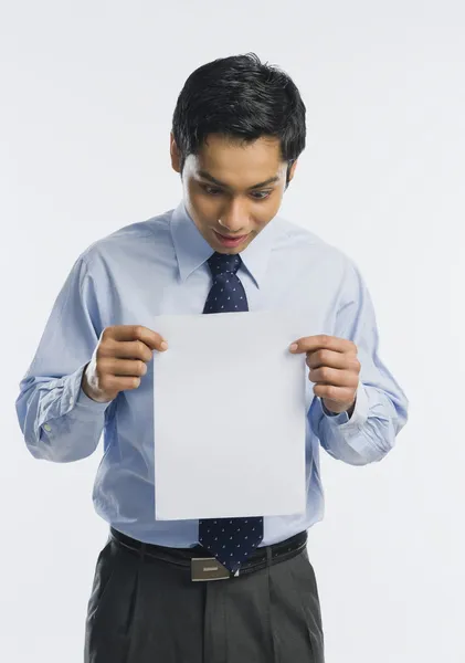 Homme d'affaires montrant une feuille de papier blanc — Photo