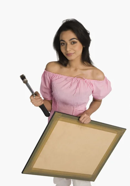 Mujer sosteniendo un martillo y una imagen —  Fotos de Stock