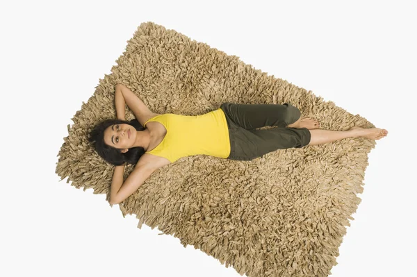 Woman lying on a rug — Stock Photo, Image