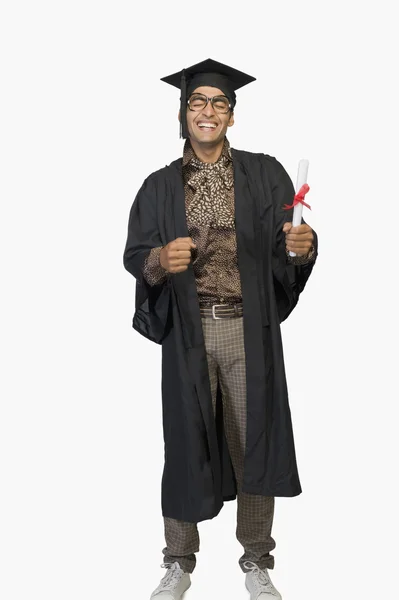 Man in a graduation gown holding a diploma — Stock Photo, Image