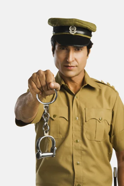 Policeman holding a pair of handcuffs — Stock Photo, Image