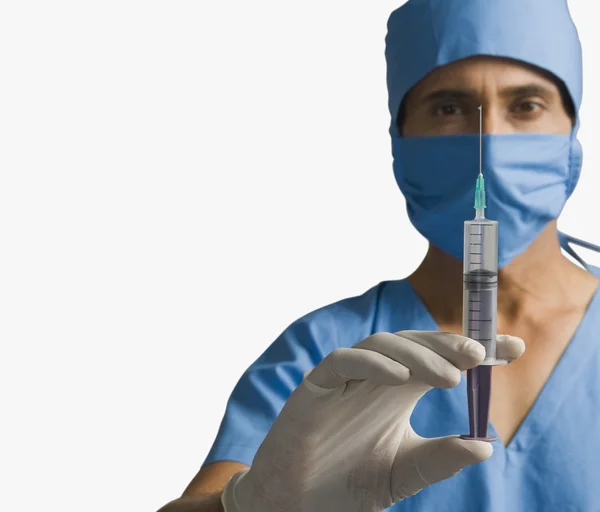 Cirurgião segurando uma seringa — Fotografia de Stock