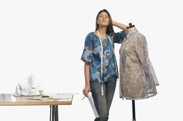 Fashion designer leaning on a mannequin — Stock Photo, Image