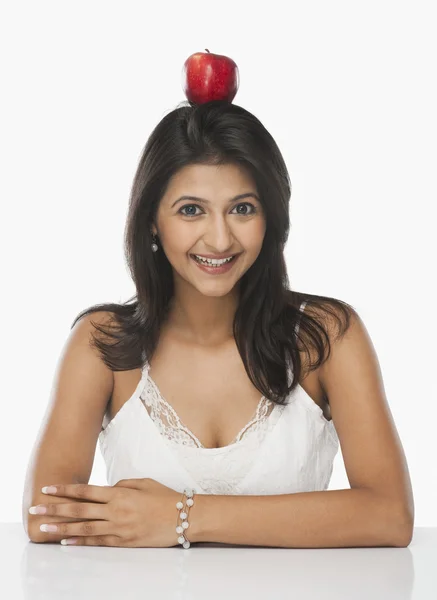 Woman balancing an apple on her head — Stock Photo, Image