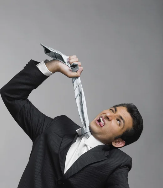 Businessman strangling himself with necktie — Stock Photo, Image