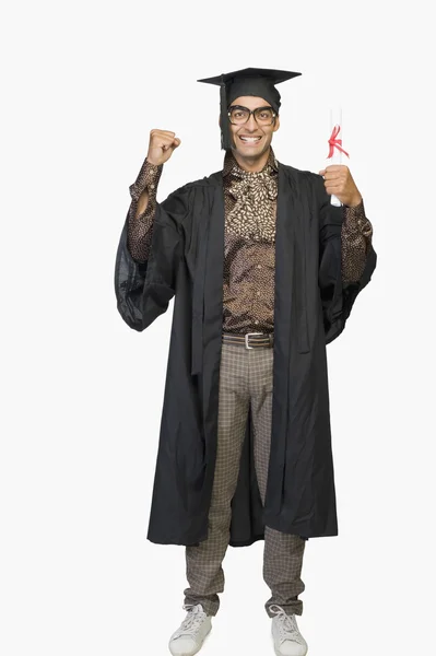 Businessman in a graduation gown holding a diploma — Stock Photo, Image