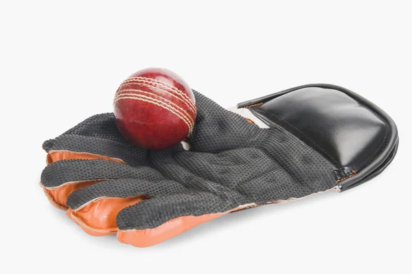 Cricket ball on a wicket keeping glove — Stock Photo, Image