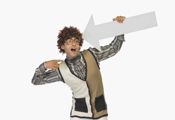 Man pointing at an arrow sign — Stock Photo, Image