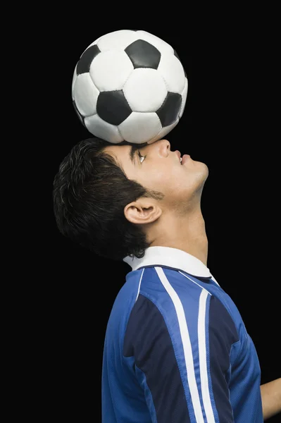 Joueur de football pratiquant avec un ballon de football — Photo