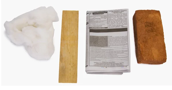 Ladrillo con un periódico y un palo de madera —  Fotos de Stock