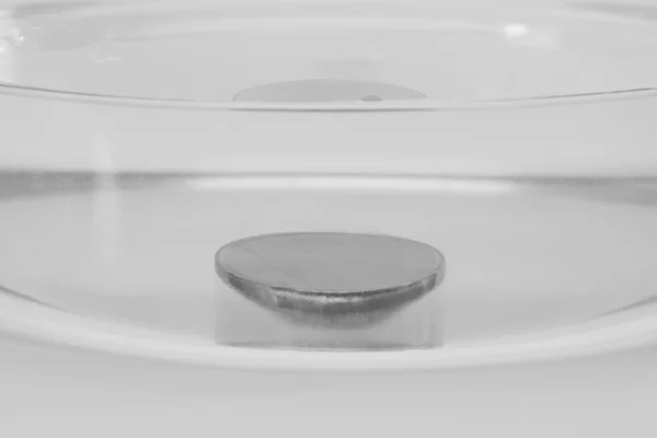 Schraube in einer Schüssel mit Wasser versenkt — Stockfoto