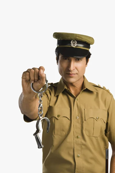 Policeman holding a pair of handcuffs — Stock Photo, Image