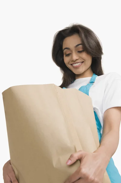 Mujer mirando en una bolsa de papel — Foto de Stock