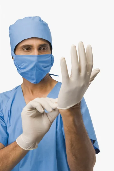 Surgeon putting on surgical gloves — Stock Photo, Image
