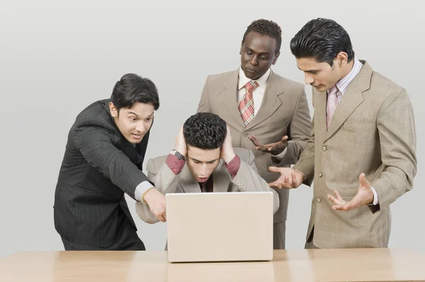 Businessmen looking shocked in front of a laptop — Stock Photo, Image