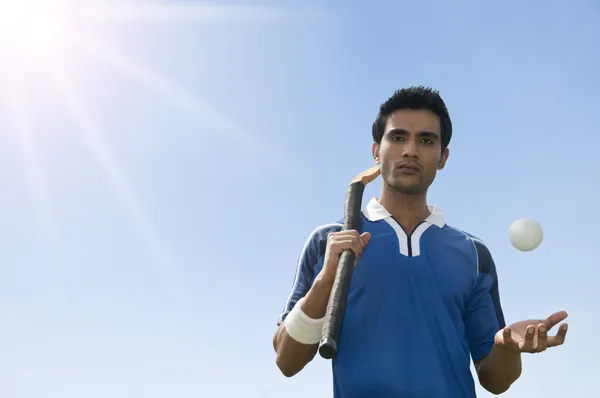 Man holding a hockey stick with a ball — Stock Photo, Image