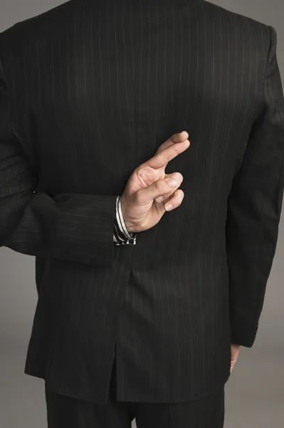 Businessman with fingers crossed behind his back — Stock Photo, Image