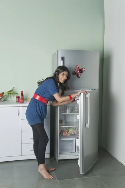 Woman opening a refrigerator — Stock Photo, Image