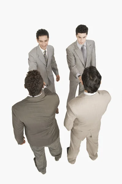 Cuatro hombres de negocios estrechando la mano — Foto de Stock