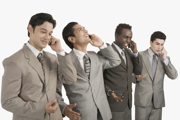 Cuatro hombres de negocios hablando en teléfonos móviles — Foto de Stock