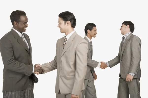 Four businessmen shaking hands — Stock Photo, Image