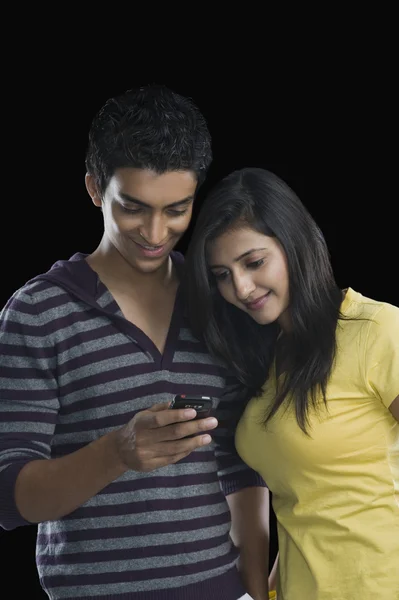 Casal olhando para um telefone celular — Fotografia de Stock