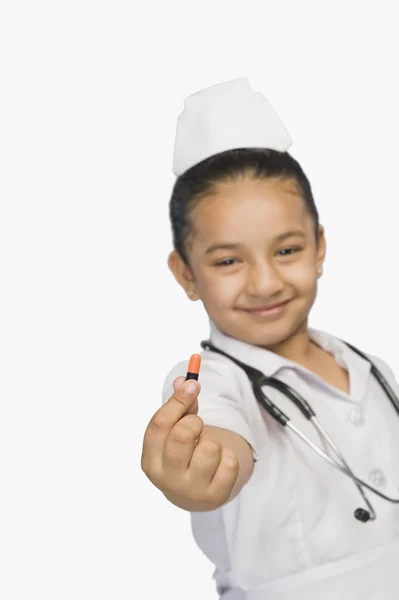 Dívka oblečená jako zdravotní sestra a drží kapsle — Stock fotografie