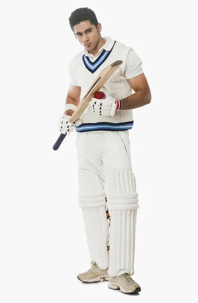 Cricket batsman holding a ball and bat — Stock Photo, Image