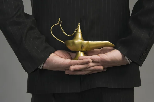 Businessman holding a magic lamp — Stock Photo, Image