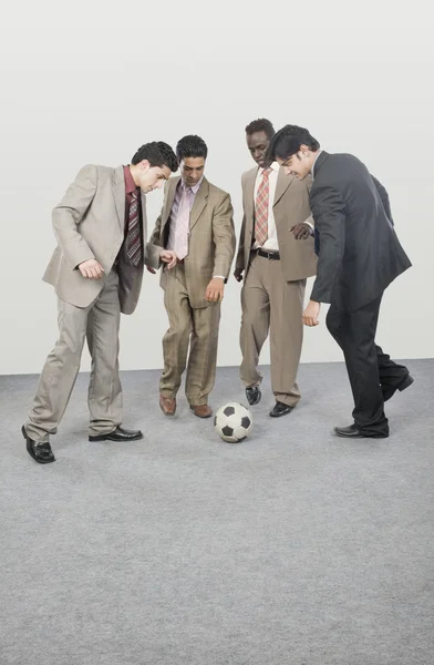 Empresários jogando com uma bola de futebol — Fotografia de Stock