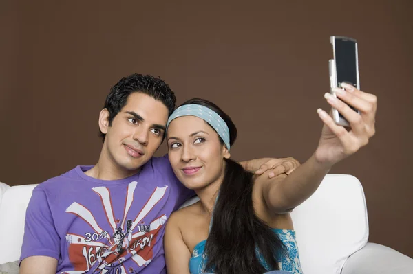 Paar nemen van een foto van zichzelf met een mobiele telefoon — Stockfoto