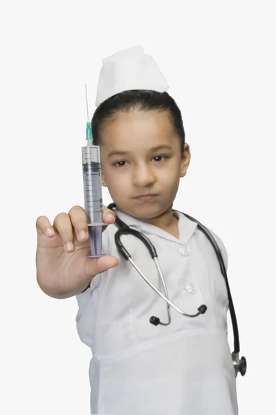 Girl dressed as a nurse and holding a syringe — Stock Photo, Image