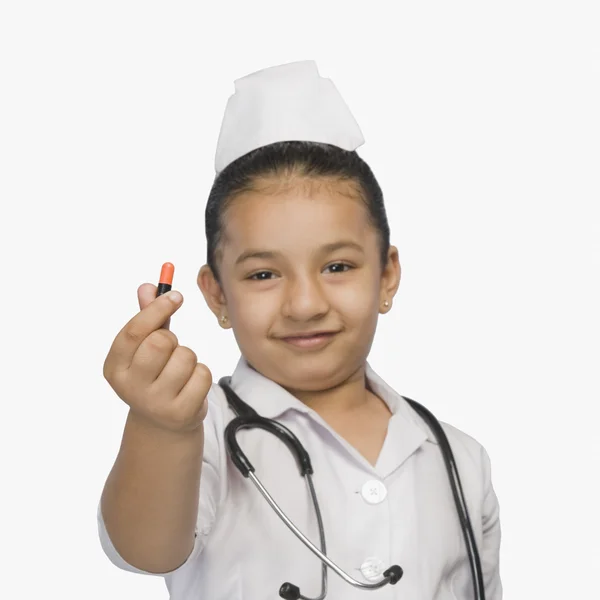 Girl dressed as a nurse and holding a capsule — Stock Photo, Image