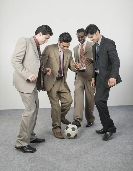 Empresarios jugando con una pelota de fútbol — Foto de Stock