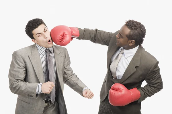 Empresario golpeando a su compañero de trabajo con guantes de boxeo —  Fotos de Stock