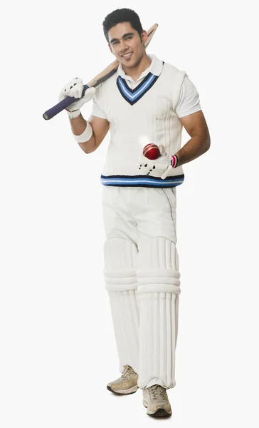 Kriket vurucu bir sopa ve top tutma — Stok fotoğraf