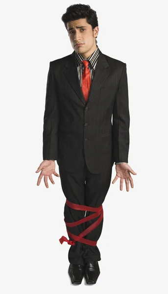 Empresário mostrando suas pernas amarradas com uma fita — Fotografia de Stock