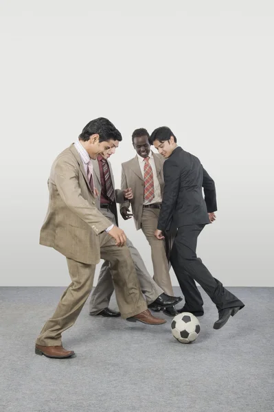Empresarios jugando con una pelota de fútbol — Foto de Stock