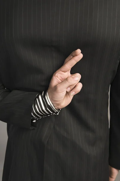 Businessman with fingers crossed behind his back — Stock Photo, Image