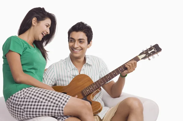 Homem tocando guitarra ao lado de uma mulher — Fotografia de Stock