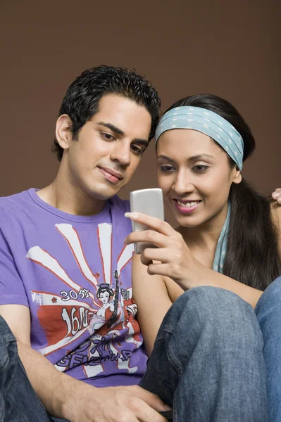 Paar lezen van een bericht op een mobiele telefoon — Stockfoto